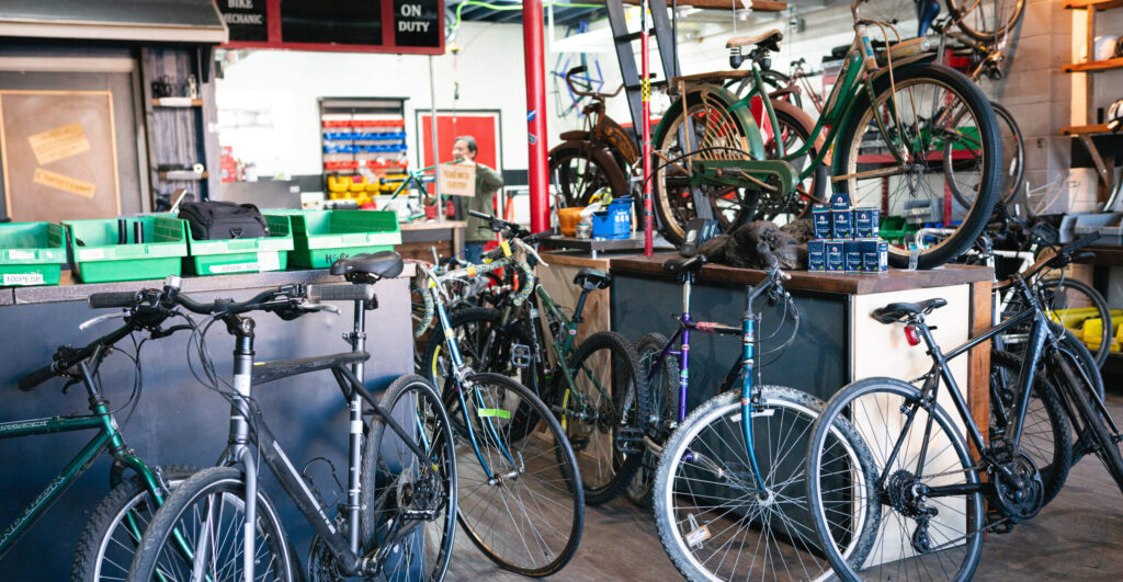Community_Bike_Shop-25-crop A shop filled with bikes and equipment.
